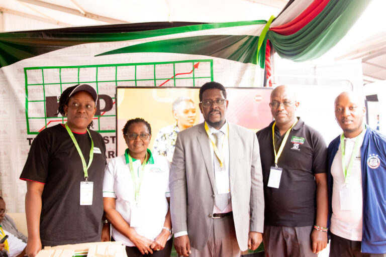 CRA Commissioner Wilfred Koitamet Olekina and KIPPRA staff pose a group when he visited KIPPRA Exhibition Booth at the conference