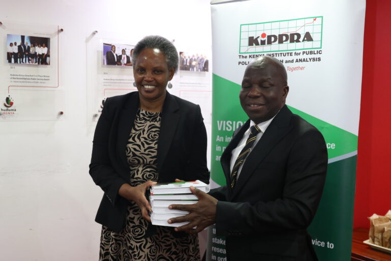 KIPPRA Executive Director Dr Rose Ngugi gives a gift to Huduma Kenya CEO Mr James Muhati during the visit