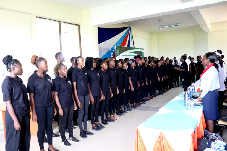 Studens from Pwani University lead participants in the National Anthem at the KMPU event