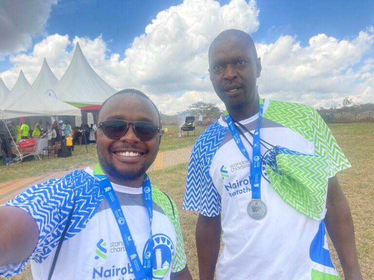 Two members of staff pose for a group photo after finishing the marathon