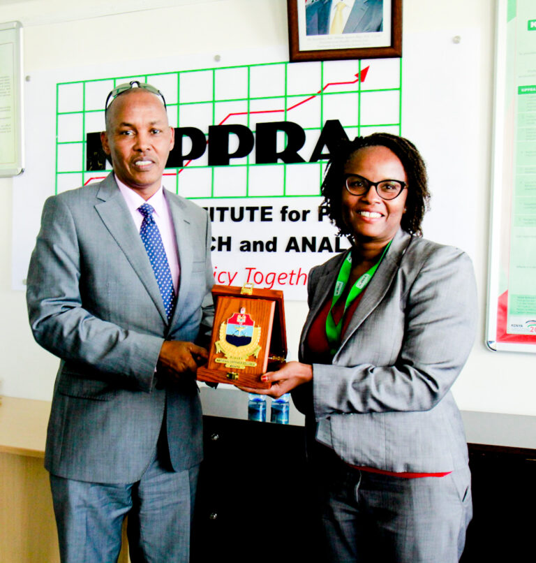 Maj Gen Rashid A. Elmi, MBS ‘ndc’ (k) ‘acsc’(USA)  presents a gift  to KIPPRA's Director Corporate Services Ms Irene Mithia